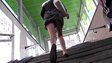 Girl in short skirt hurries up on stairs